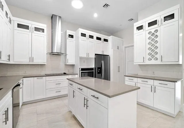 a kitchen with white cabinets and stainless steel appliances