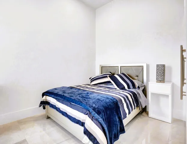 a bedroom with a bed and lamp