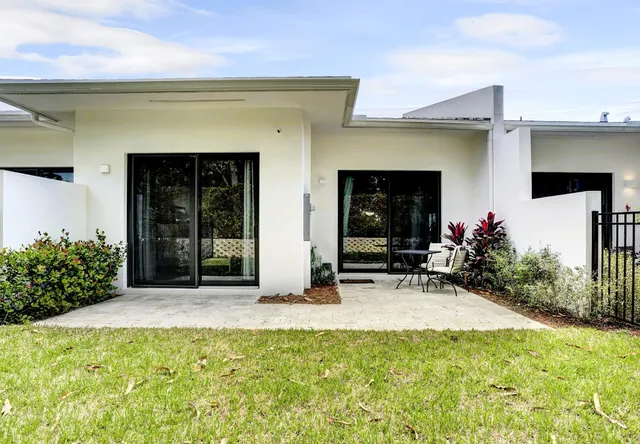 a view of a house with potted plants in front of door