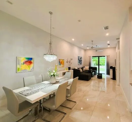 a living room with furniture kitchen view and a chandelier