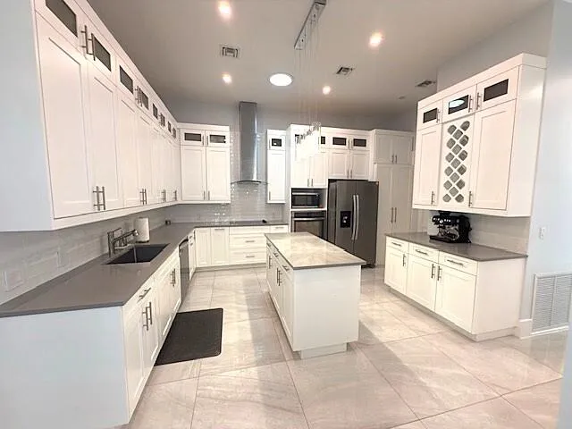 a kitchen with a sink a stove top oven and white cabinets