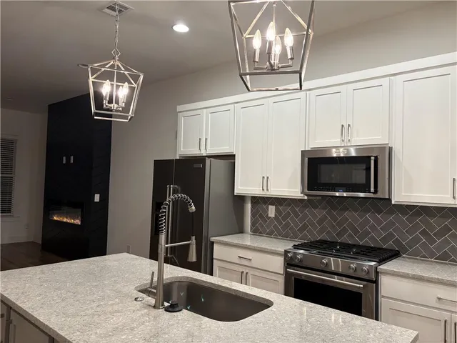 a kitchen with stainless steel appliances granite countertop a sink stove and refrigerator