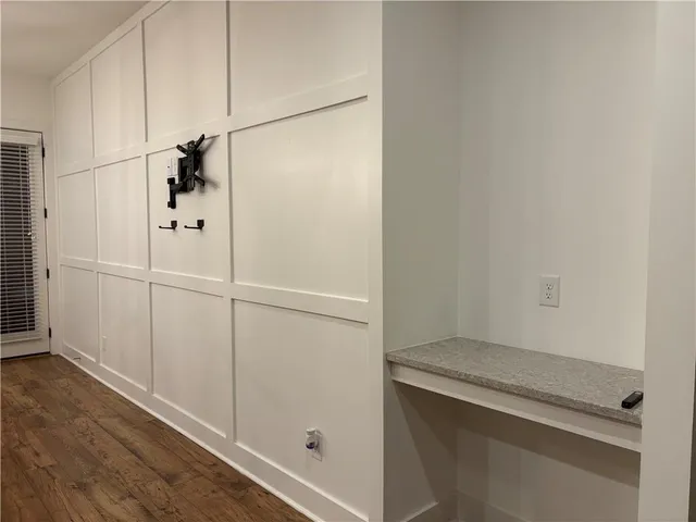 an empty room with wooden floor a ceiling fan and windows