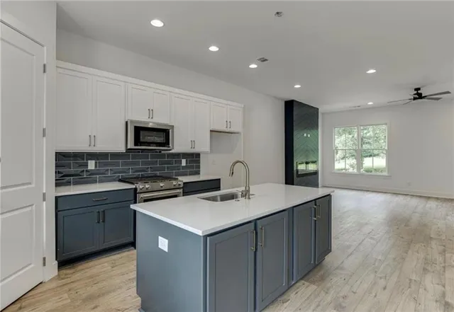 a kitchen with a sink a microwave and cabinets
