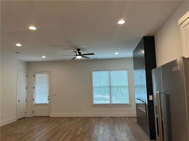 a kitchen with a refrigerator a sink and wooden floor