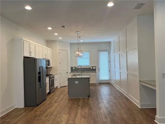 a kitchen with stainless steel appliances granite countertop a refrigerator a sink a stove a microwave and island