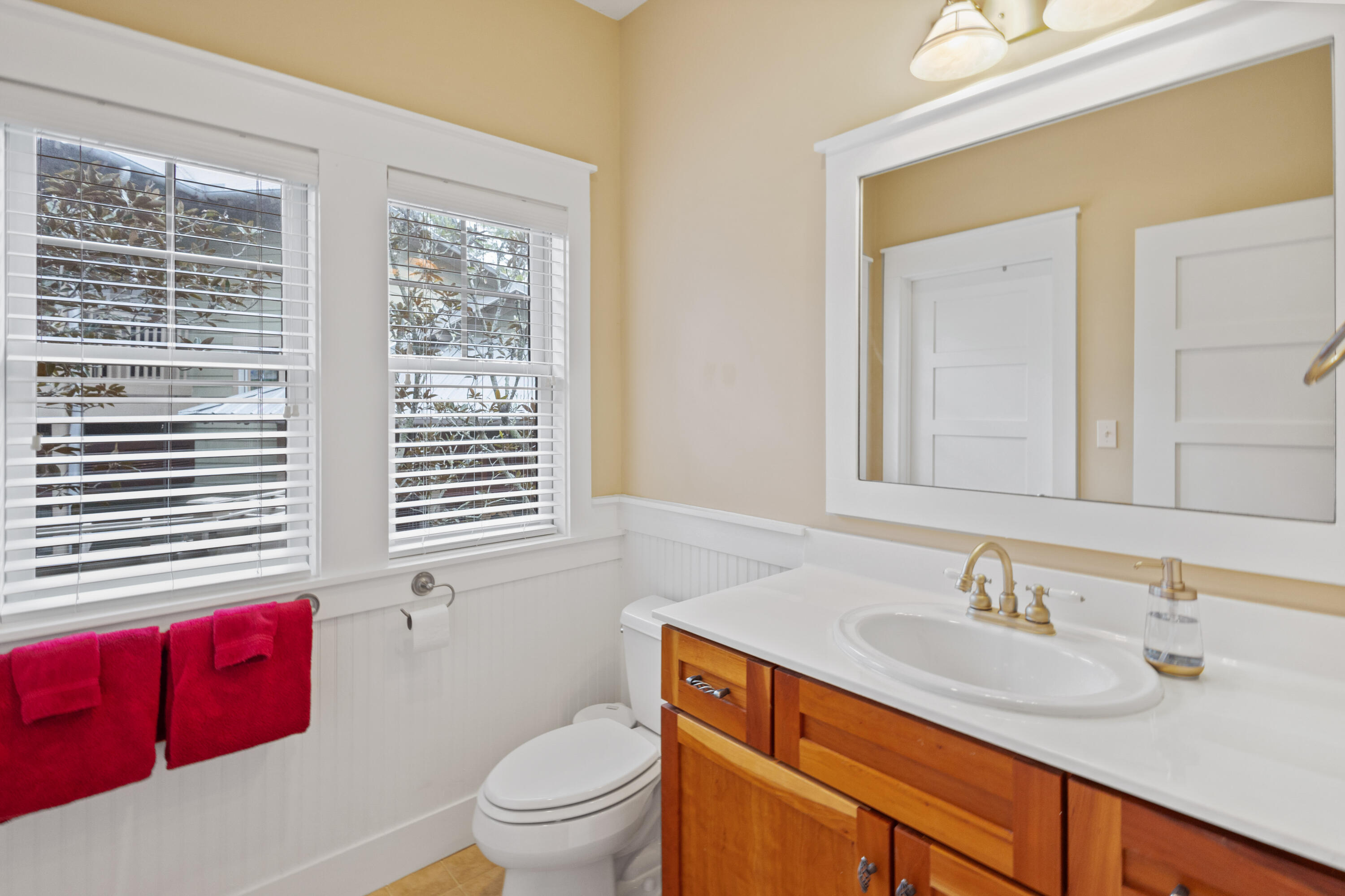 58 South Summit Drive Santa Rosa Beach, FL 32459 - Photo 31 of 40 a bathroom with a granite countertop toilet a sink a mirror and a window