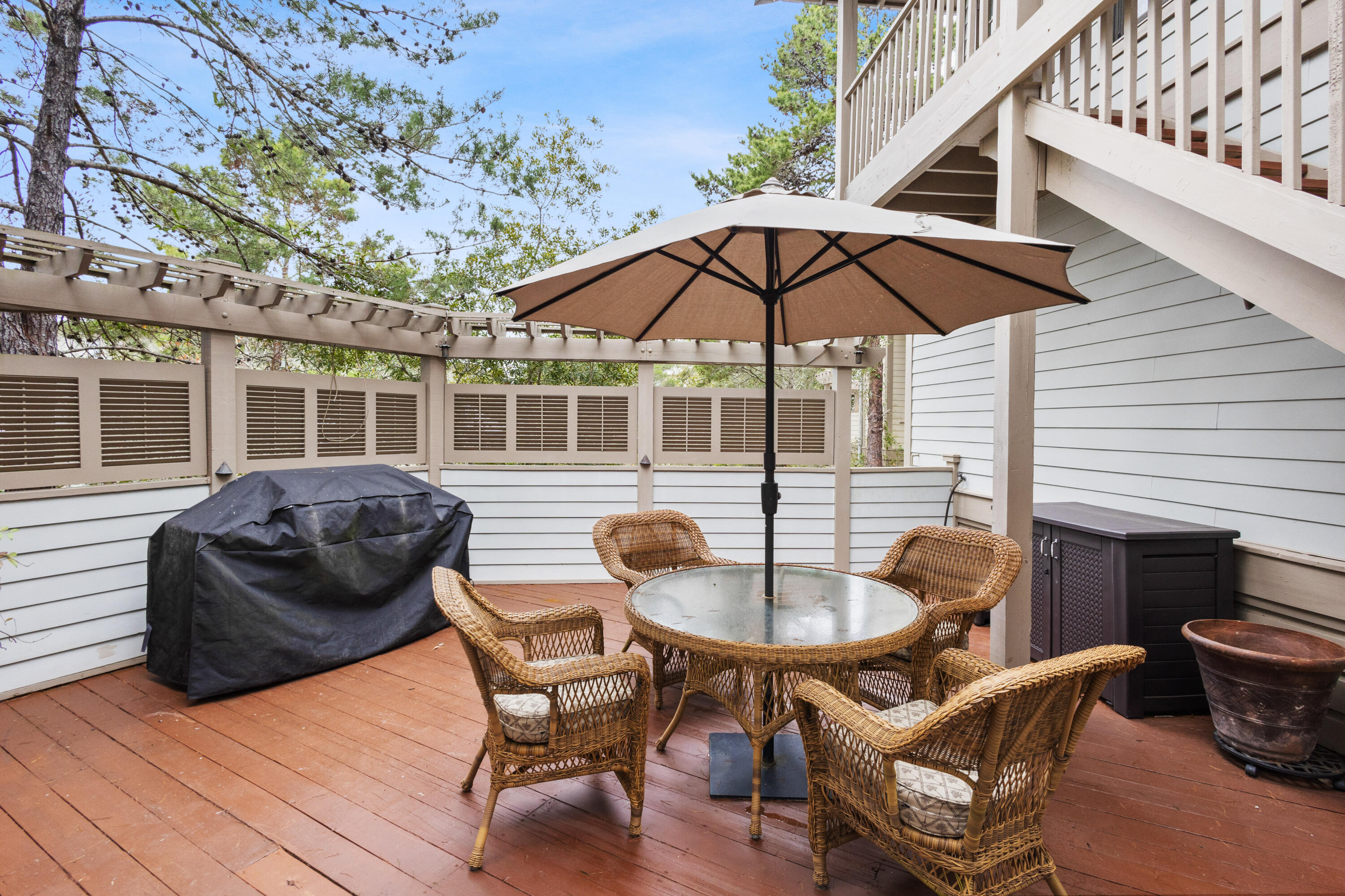 58 South Summit Drive Santa Rosa Beach, FL 32459 - Photo 4 of 40 a view of a roof deck with table and chairs under an umbrella with wooden floor