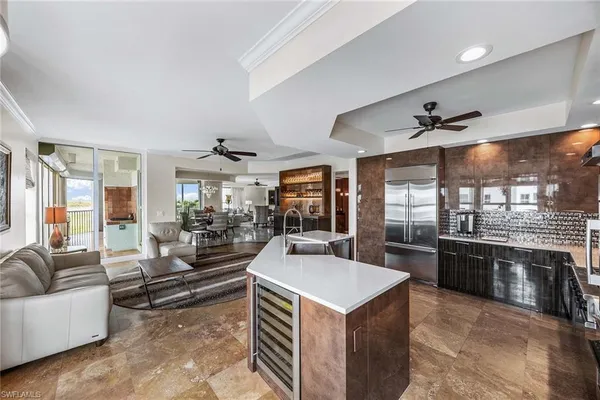 a kitchen with a stove a refrigerator a couch a dining table and chairs