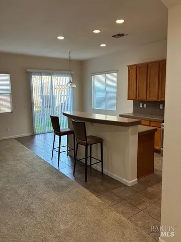 an empty room with windows fireplace and table