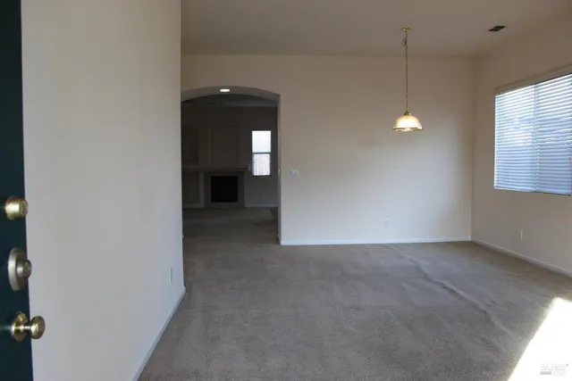 an empty room with windows and cabinet