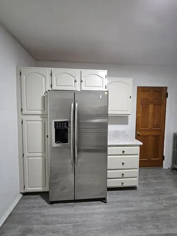 a kitchen with granite countertop cabinets and refrigerator