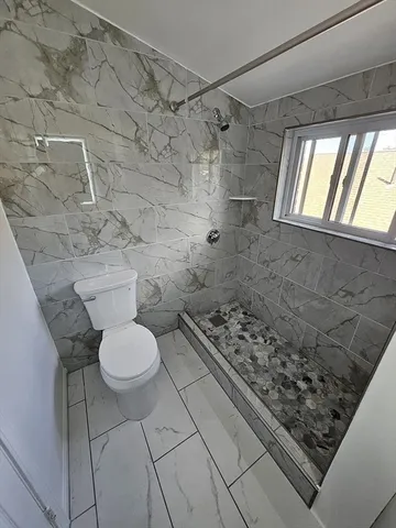 a bathroom with a toilet and a shower