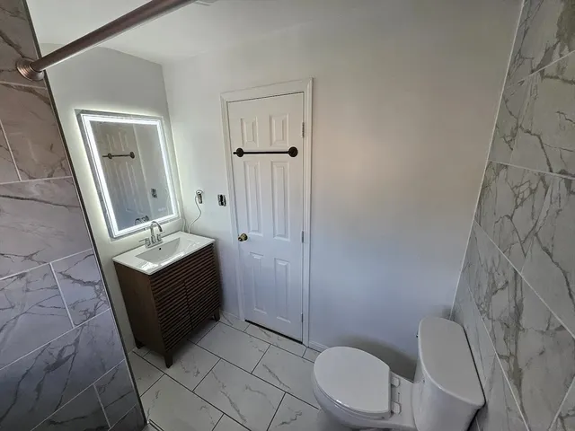 a bathroom with a toilet a sink and a mirror