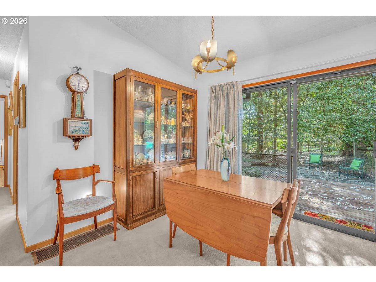9200 Southwest Elrose Court Portland, OR 97224 - Photo 14 of 46 a dining room with wooden floor a chandelier a glass table and chairs