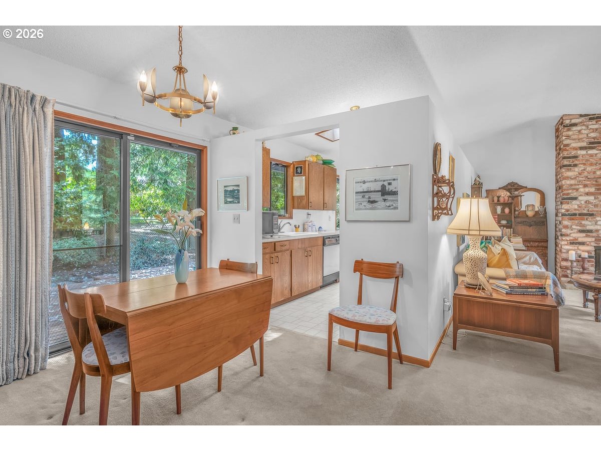 9200 Southwest Elrose Court Portland, OR 97224 - Photo 15 of 46 a dining room with wooden floor a chandelier a glass table and chairs