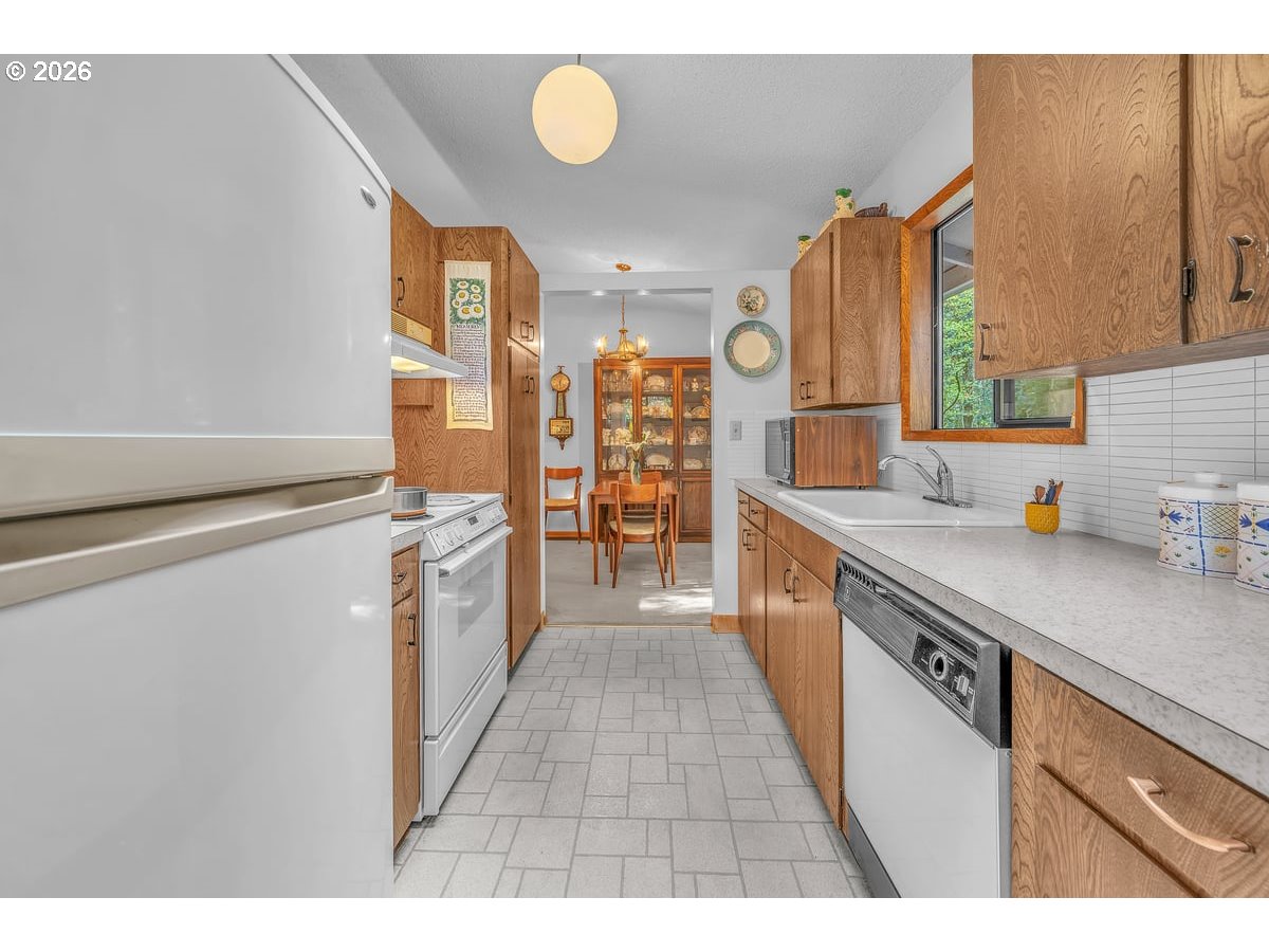 9200 Southwest Elrose Court Portland, OR 97224 - Photo 17 of 46 a kitchen with stainless steel appliances granite countertop a sink and cabinets
