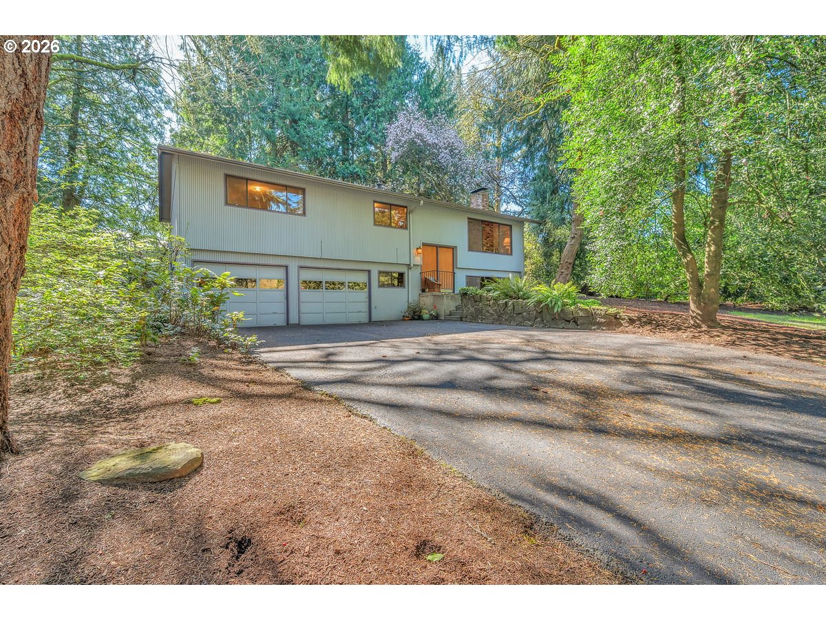 9200 Southwest Elrose Court Portland, OR 97224 - Photo 2 of 46 a backyard of a house with large trees and a wooden fence
