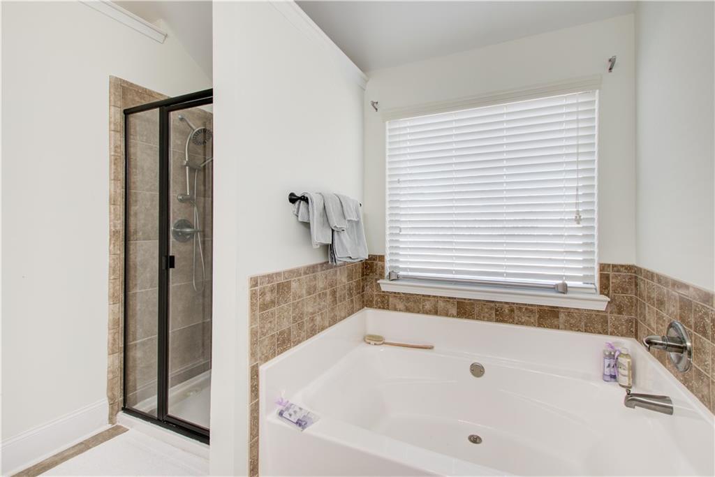 1979 Trinity Mill Drive Dacula, GA 30019 - Photo 19 of 26 a bathroom with bathtub and shower