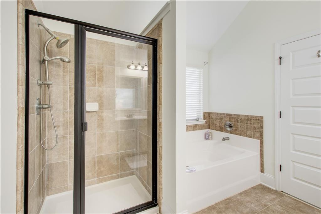 1979 Trinity Mill Drive Dacula, GA 30019 - Photo 24 of 26 a bathroom with a bathtub and a shower