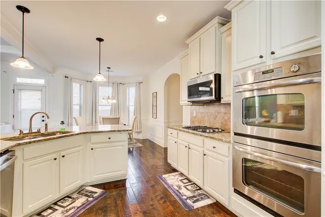 a large kitchen with cabinets and wooden floor