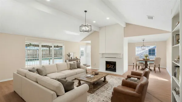 a living room with furniture fireplace and a large window