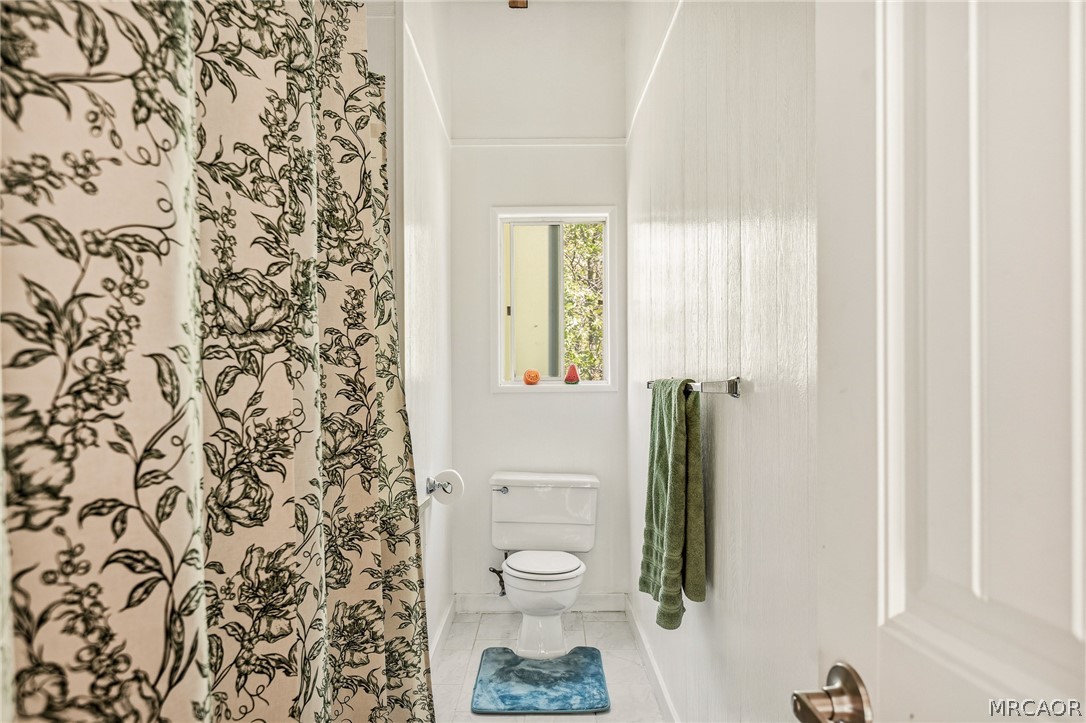 316 Pioneer Road Lake Arrowhead, CA 92352 - Photo 23 of 35 view of a bathroom with a toilet and a shower curtain