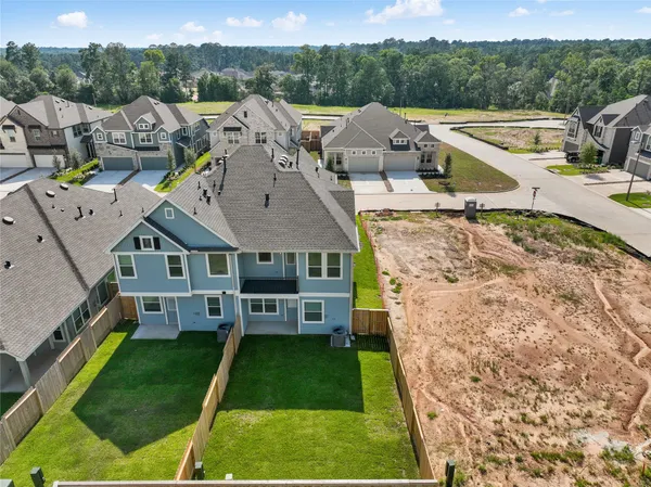 an aerial view of a house with a garden and lake view