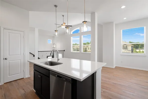 a kitchen with a sink a counter space and wooden floor
