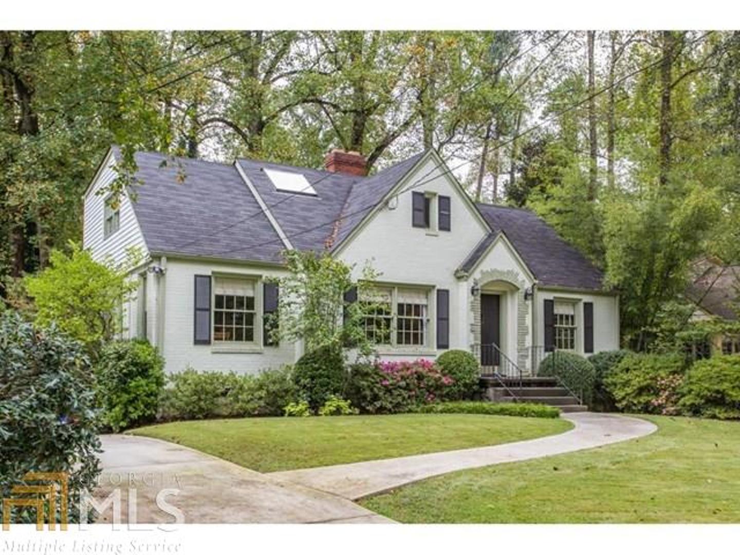 a front view of a house with a yard and trees