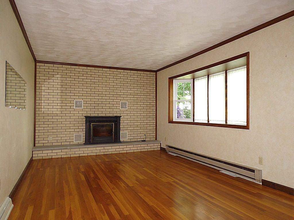 190 Deerfield Road Washington, PA 15301 - Photo 5 of 25 Living Room with large bay window, brick accent wall and cozy wood-burning stove insert