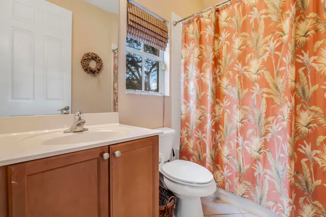 a bathroom with a granite countertop sink and a toilet
