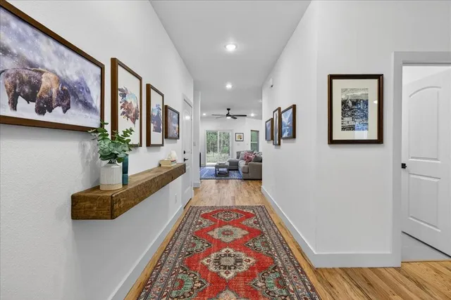 a view of a hallway with wooden floor and a couch