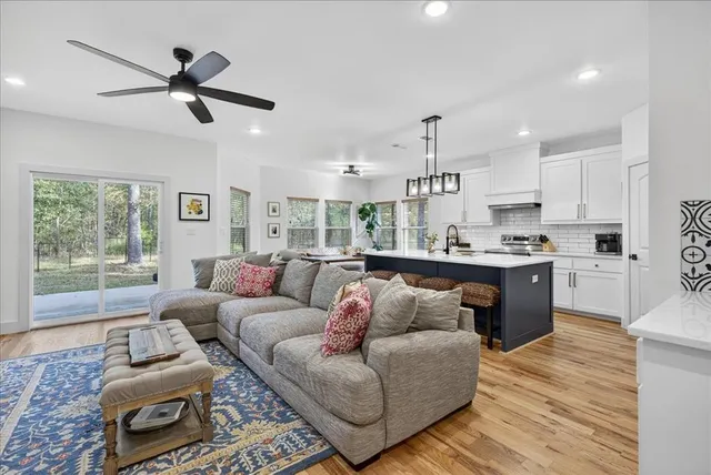 a living room with furniture and kitchen view