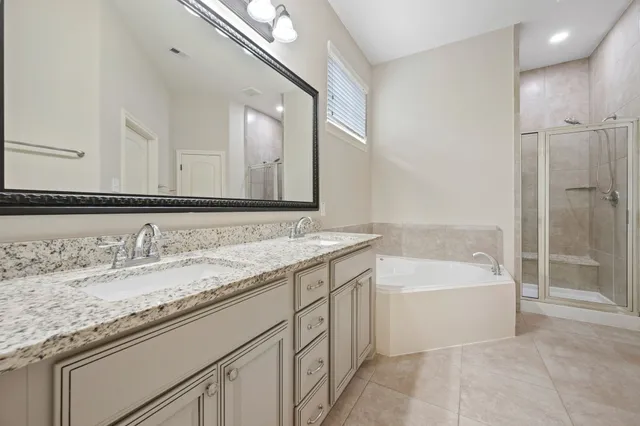 a bathroom with a granite countertop sink mirror and bathtub