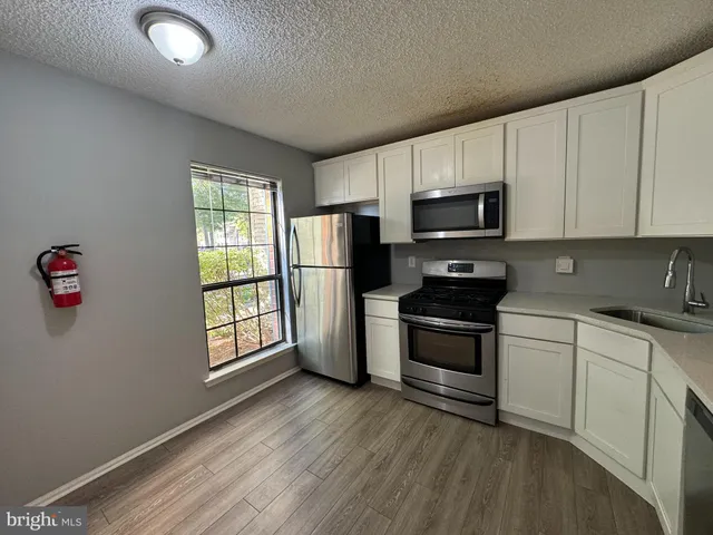 a kitchen with granite countertop a stove a microwave a sink and a refrigerator