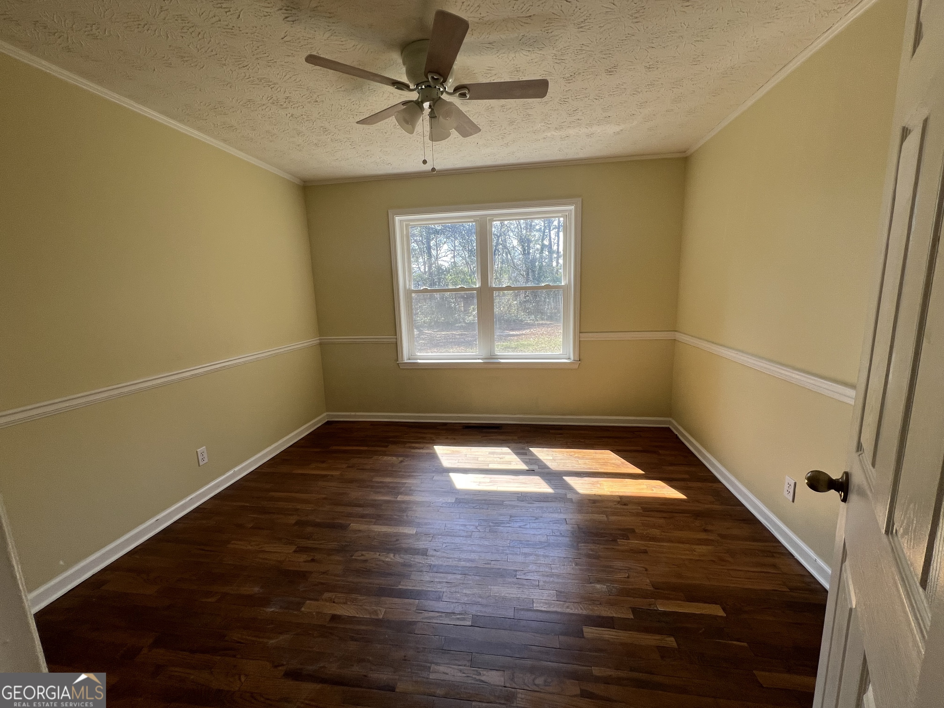 1342 North Jefferson Street Dublin, GA 31021 - Photo 11 of 15 a view of empty room with wooden floor and fan