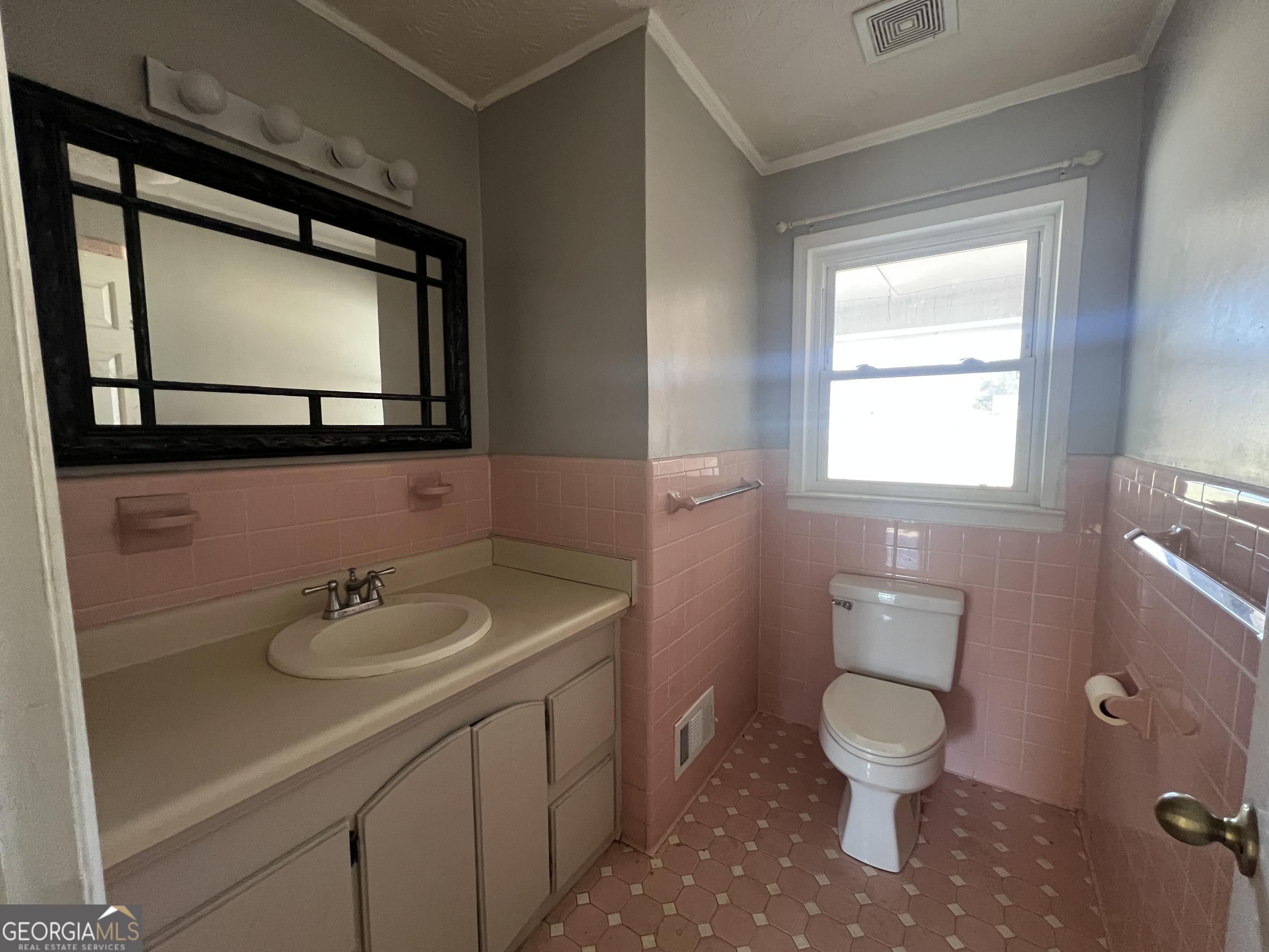 1342 North Jefferson Street Dublin, GA 31021 - Photo 12 of 15 a bathroom with a toilet sink and mirror
