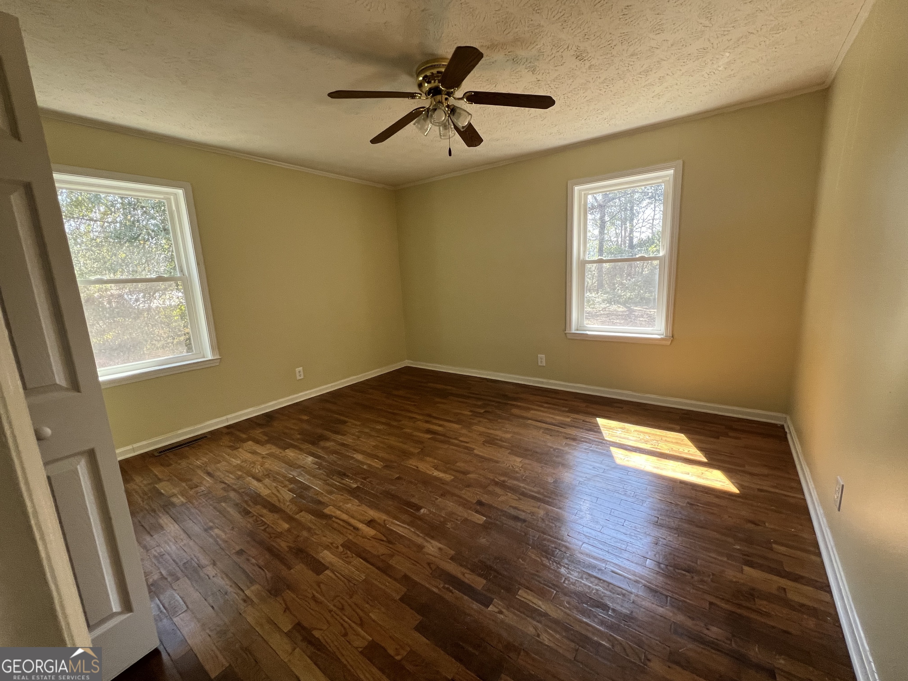 1342 North Jefferson Street Dublin, GA 31021 - Photo 13 of 15 a view of an empty room with a window and wooden floor