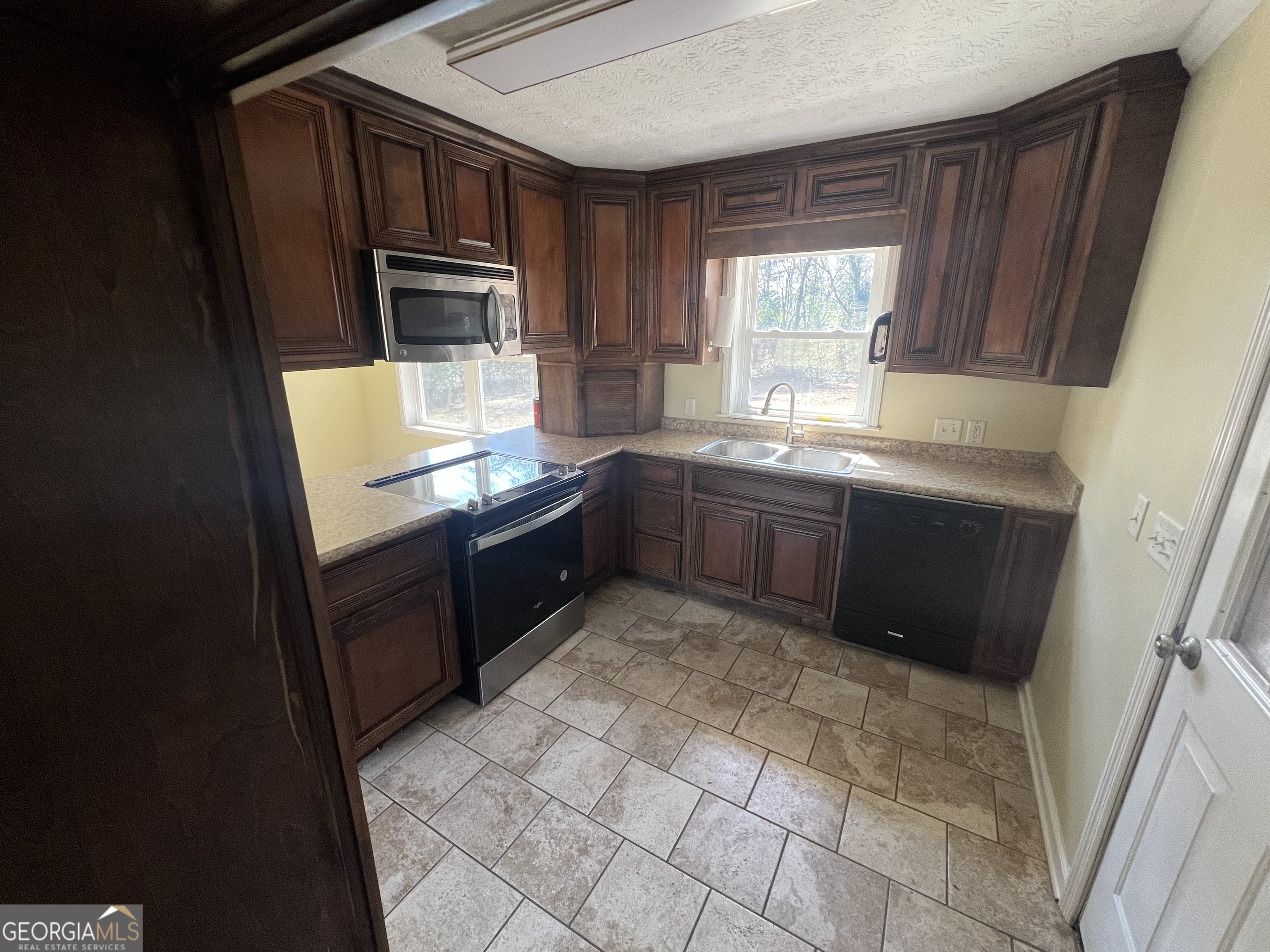 1342 North Jefferson Street Dublin, GA 31021 - Photo 8 of 15 a kitchen with granite countertop a refrigerator and a stove top oven