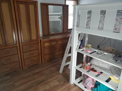 a view of bedroom with baby crib and wooden floor