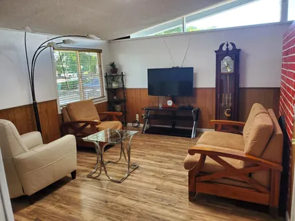 a living room with furniture a flat screen tv and a floor
