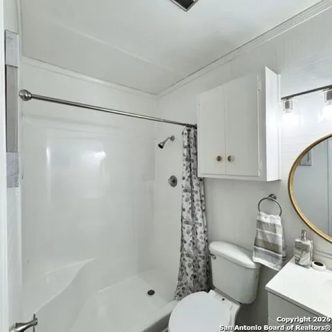 a bathroom with a toilet and a shower