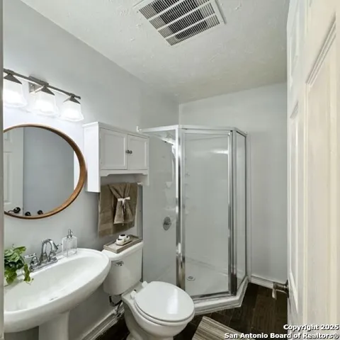 a bathroom with a sink a toilet and shower