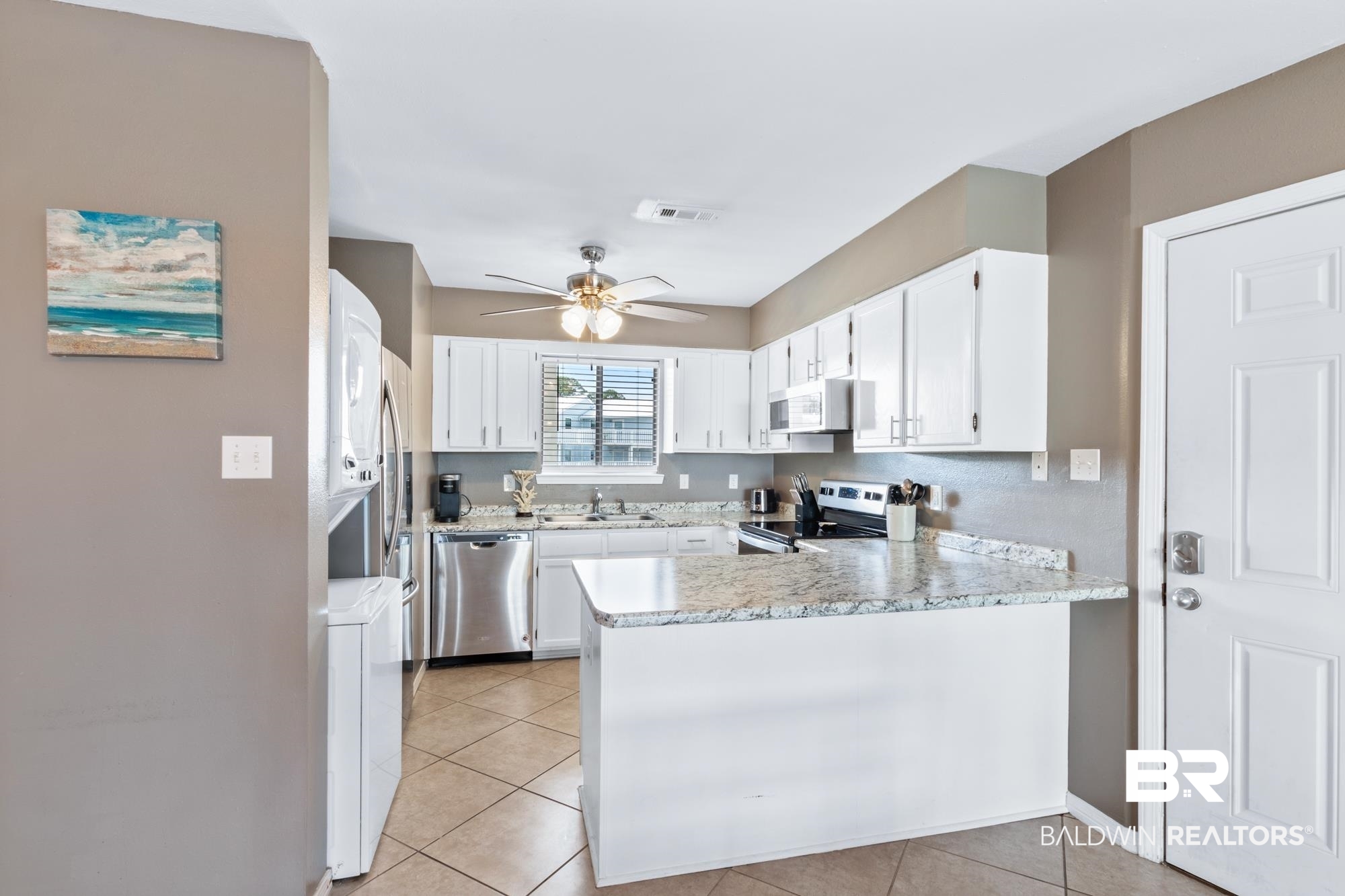25925 -C Canal Road, Unit 203 Orange Beach, AL 36561 - Photo 6 of 57 Kitchen featuring stainless steel appliances, light tile patterned floors, kitchen peninsula, and ceiling fan