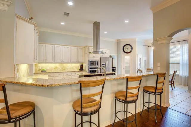 a kitchen with stainless steel appliances granite countertop a table and chairs in it