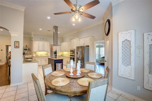 a kitchen with stainless steel appliances granite countertop a dining table and chairs