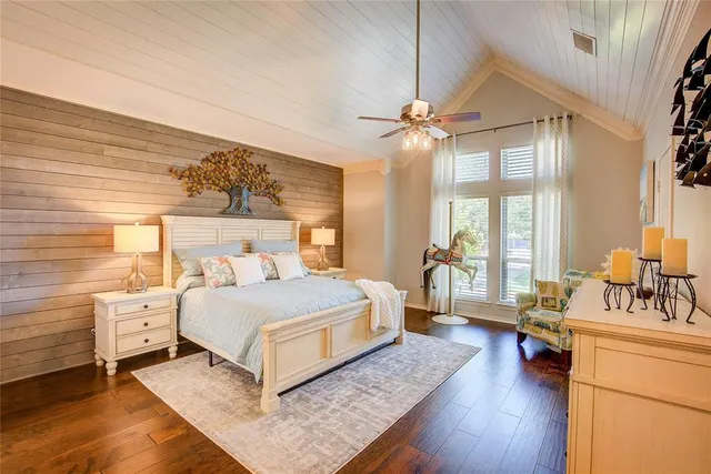 a bedroom with a bed a dresser and a chandelier