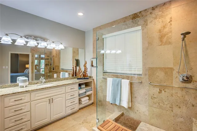 a bathroom with a granite countertop double vanity sink and a mirror