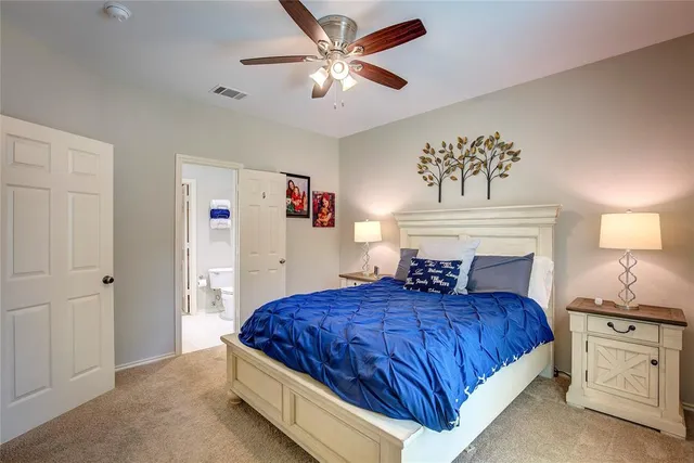 a en suite bathroom with a granite countertop double vanity sink and a mirror